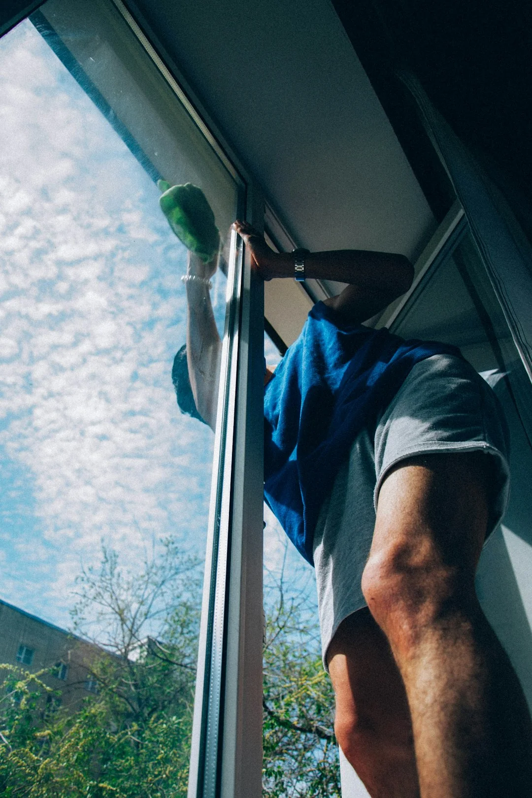 services-01 Des professionnels nettoient les vitres d’un gratte-ciel à l’aide de cordes dans un environnement urbain.